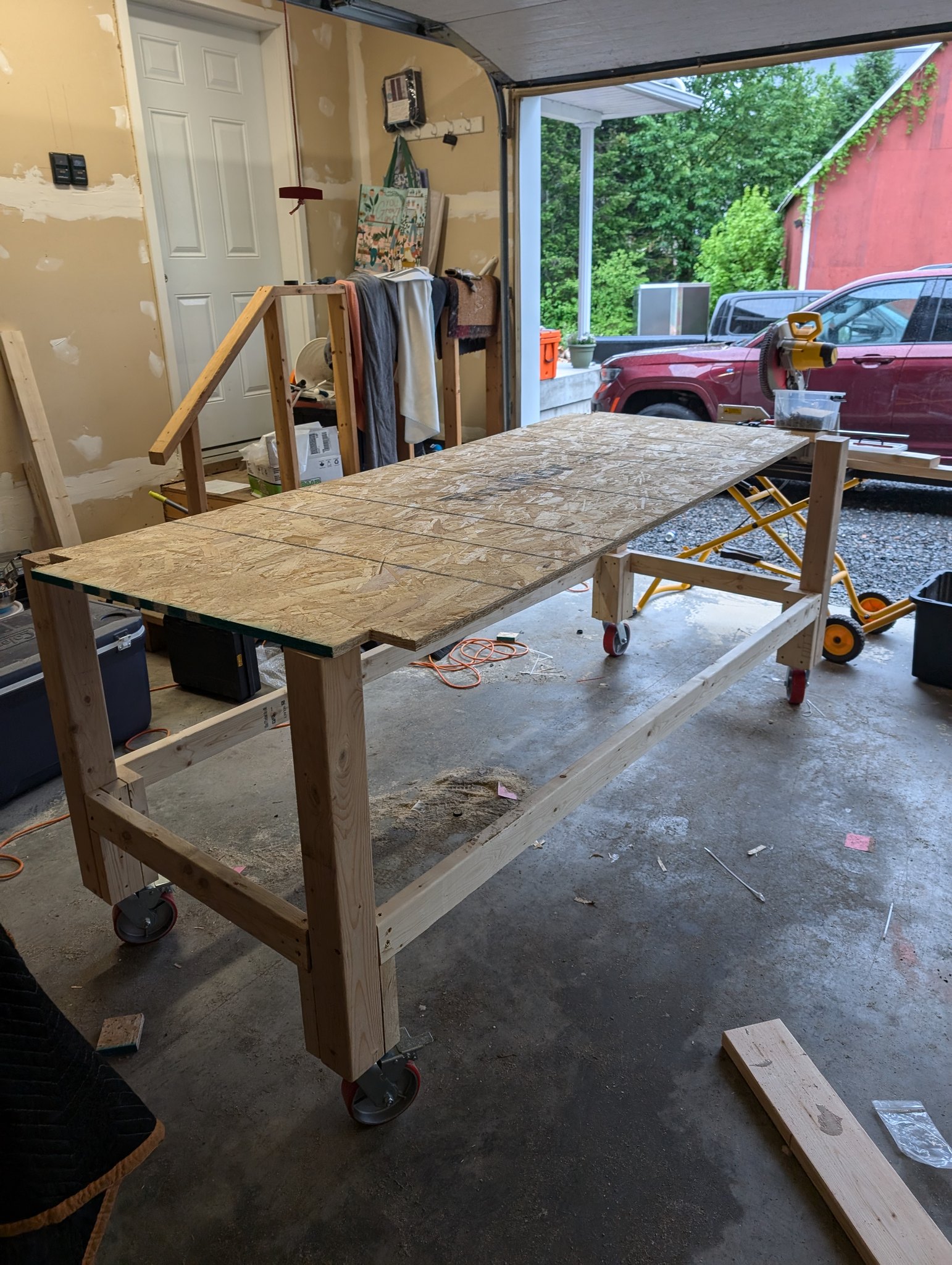 Timber workbench frame on casters with a notched OSB panel resting across the top
